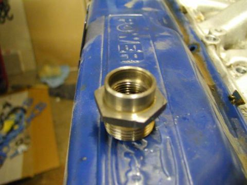 1979 Ford Bronco - A close-up view of a threaded fitting on a blue engine valve cover, with text visible.
