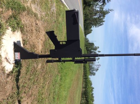 1992 Ford Bronco - A black, gun-shaped object is mounted on a concrete base next to a road. The object has a long barrel and what appears to be a magazine and…