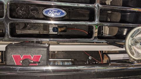 1995 Ford Bronco - Close-up view of engine bay components, including hoses and electrical connections.