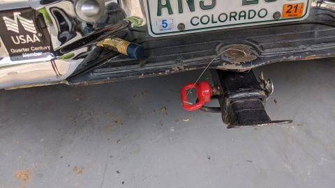 1995 Ford Bronco - Close-up of a vehicle's rear bumper and trailer hitch assembly, showing a Colorado license plate and a red tow hook.