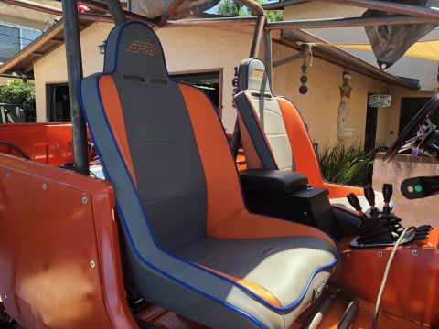 1992 Jeep Wrangler - The interior of an orange off-road vehicle shows two PRP racing seats with gray and orange upholstery and blue piping. The view also includ…