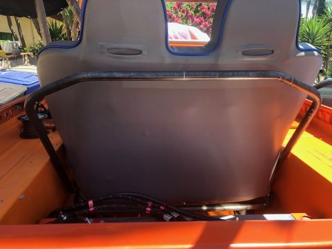 1992 Jeep Wrangler - The rear interior of an orange boat shows a grey seat with blue trim, supported by a metal frame. Black hoses with red clamps are visible b…