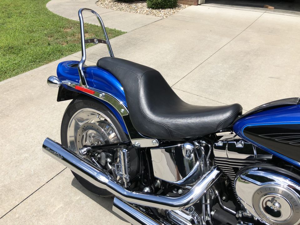 Blue Harley-Davidson Softail motorcycle rear section with chrome sissy bar and exhaust