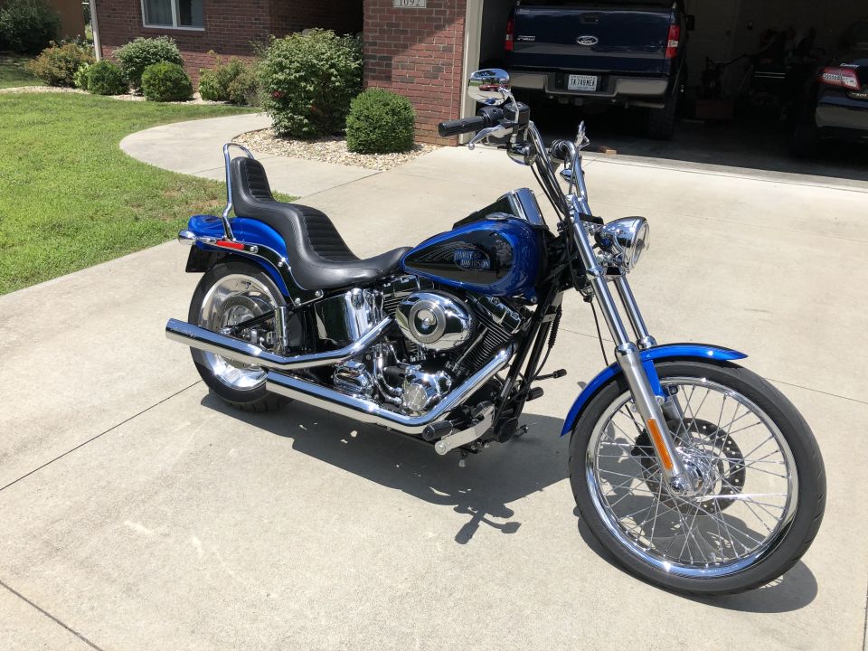 Blue Harley-Davidson Softail motorcycle parked on a driveway.