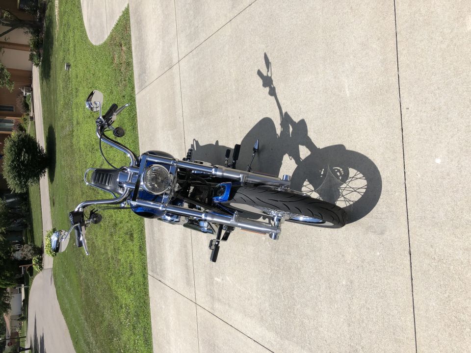 Blue and chrome motorcycle parked on a concrete driveway, top-down view.