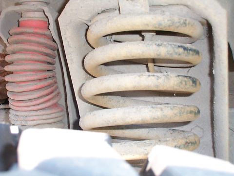 1979 Ford Bronco - Detail of vehicle suspension components, showing two distinct coil springs and surrounding metalwork.