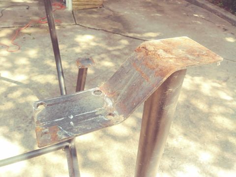 1996 Ford Bronco - A rusted metal bracket with four bolt holes is attached to a black metal pole. The bracket is bent at an angle and appears to be part of a…
