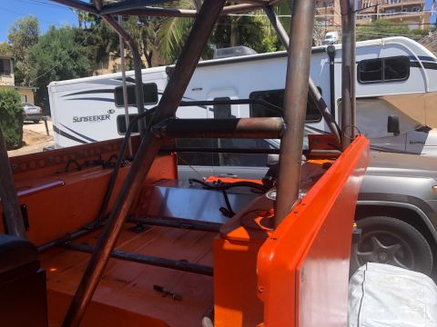 1992 Jeep Wrangler - Custom roll cage and fuel tank visible in the interior of an orange Jeep.