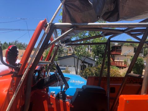 1992 Jeep Wrangler - Custom roll cage installed on an orange vehicle's interior, with another vehicle in the background.