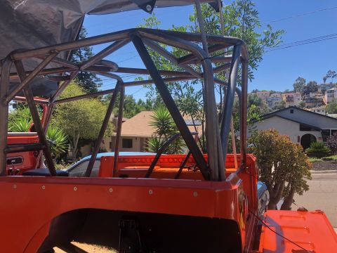 1992 Jeep Wrangler - Custom roll cage installed on an orange Jeep, likely for off-road use.