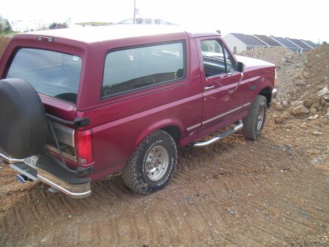 1994 Ford Bronco - Maroon 1994 Ford Bronco sits on a dirt road near a construction site.