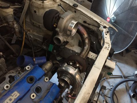 1993 Mercury Tracer - Custom turbo setup in an engine bay, a blue Mazda valve cover and large industrial fan.