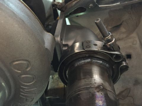 1993 Mercury Tracer - This image shows a close-up view of a turbocharger's exhaust connection, a metal clamp and bolt assembly.