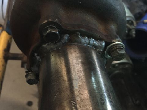 1993 Mercury Tracer - Close-up of a metal exhaust pipe connection, showing bolted flanges and welding.