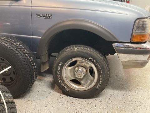 1998 Ford Ranger - A blue Ford Ranger XLT is shown with a spare tire and a new tire nearby.