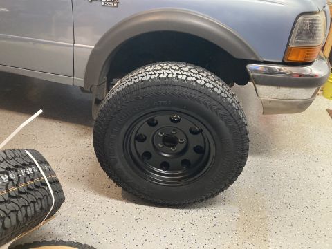 1998 Ford Ranger - Close-up of a 1998 Ford Ranger XLT's front wheel and fender assembly, highlighting the tire and rim.