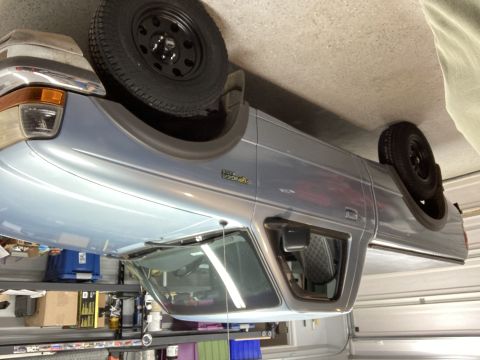 1998 Ford Ranger - A light blue 1998 Ford Ranger pickup truck is shown in a garage with a spare tire mounted in the bed.