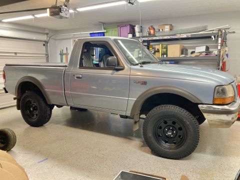 1998 Ford Ranger - A silver 1998 Ford Ranger pickup truck is parked in a garage, showing its side profile.