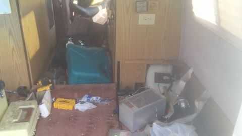 1988 Dodge RV/Conversion Chassis - The interior of this RV is filled with various items, including a teal container and tools.