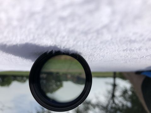 1995 Mercury Grand Marquis - View through a circular interior mirror shows a reflective lake and distant trees.