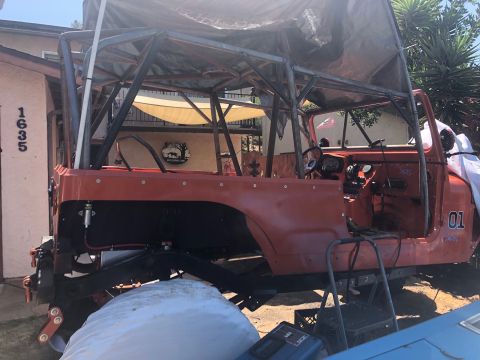 1992 Jeep Wrangler - Modified Jeep CJ-7 body with custom roll cage, seen from the side. The vehicle appears to be under construction.