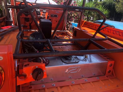 1992 Jeep Wrangler - The interior of an off-road vehicle is shown, a prominent roll cage and a large, custom-mounted fuel tank.