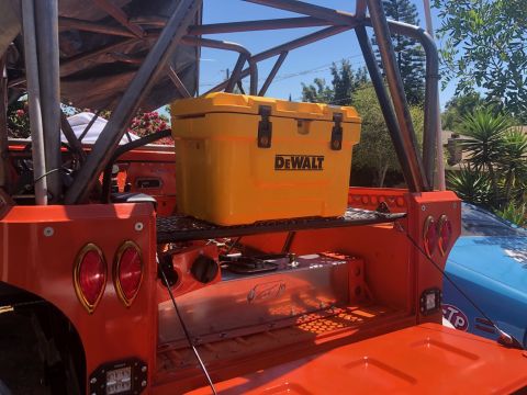 1992 Jeep Wrangler - Custom vehicle bed setup with a DeWalt cooler and fuel tank, a roll cage and another vehicle in the background.