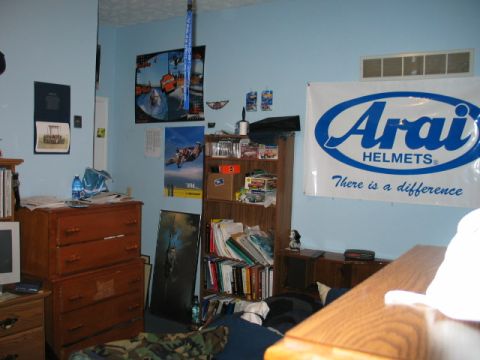 1995 Ford Bronco - A bedroom interior a large Arai Helmets banner and various posters on a light blue wall.