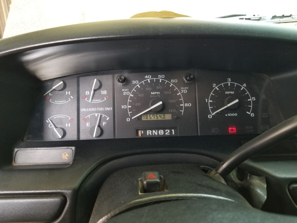 Dashboard gauges showing speed, RPM, fuel level, temperature, and odometer reading 185754.0