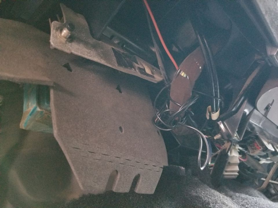 The pushbutton switch through the steel bracket & wad of wire are remnants of the RKE 600Plus system. Its removal is probably why the Right unlock switch doesn't work.

Remove abandoned wiring & repair damage: $60/hr clock time