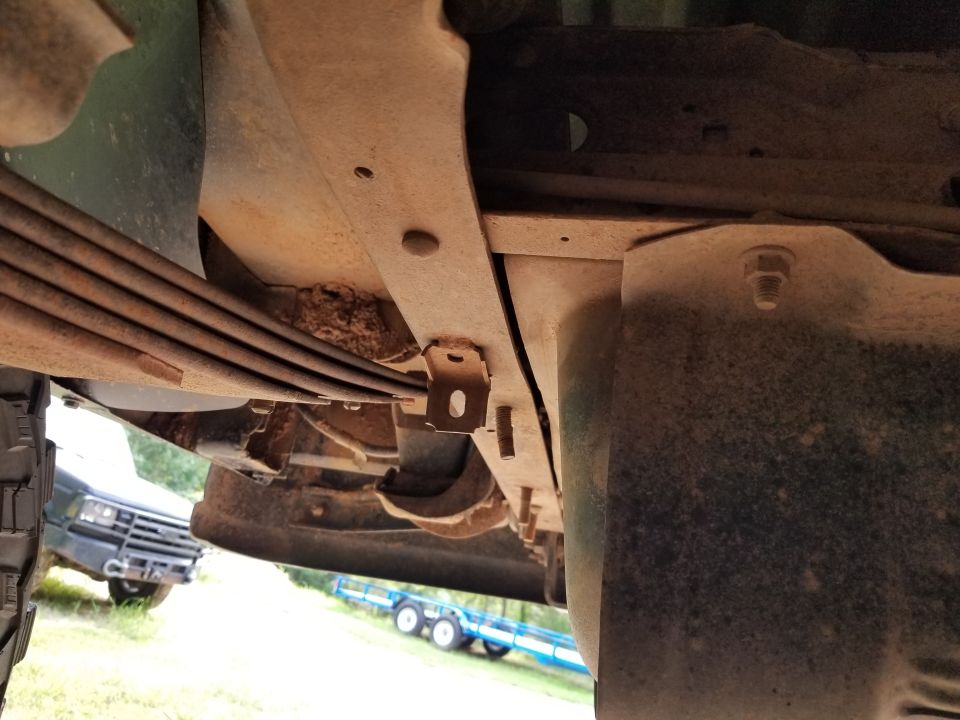 There's some minor frame damage where the hitch receiver was, and an extra tab welded to the frame (probably a poor replacement for the exhaust hanger).

Remove welded tab $15