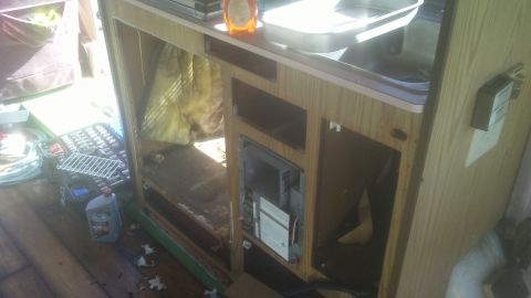 1988 Dodge RV/Conversion Chassis - The interior of an RV shows exposed insulation and empty cabinet spaces, with tools scattered around.