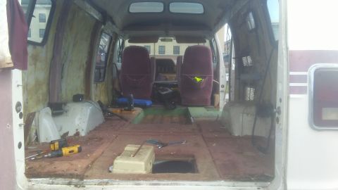 1988 Dodge RV/Conversion Chassis - The interior of a van is shown with its components removed, revealing the bare structure and two seats.