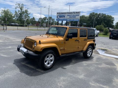 2009 Harley-Davidson FLH - A yellow Jeep Wrangler Unlimited is parked outside under a partly cloudy sky.
