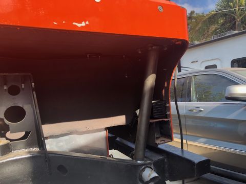 1992 Jeep Wrangler - Close-up of orange roll cage tubing and chassis components, with a silver SUV and RV visible in the background.