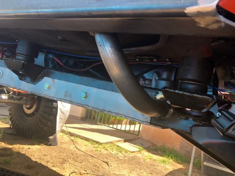 1992 Jeep Wrangler - The underside of a heavily modified vehicle shows custom suspension components and exhaust piping.