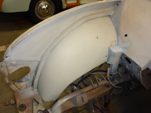 1969 MINI Cooper - Close-up view of a car's wheel well and fender area during restoration. The Supermotors.net logo is visible in the lower right corner.