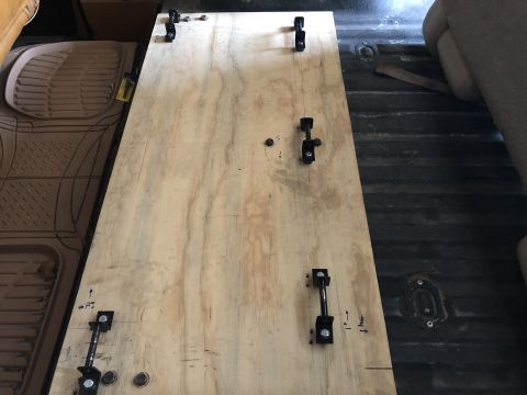 1980 Ford Bronco - Custom plywood floor with metal latches installed in the rear interior of a vehicle.
