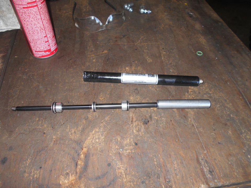 Shock absorber assembly and parts on a wooden workbench