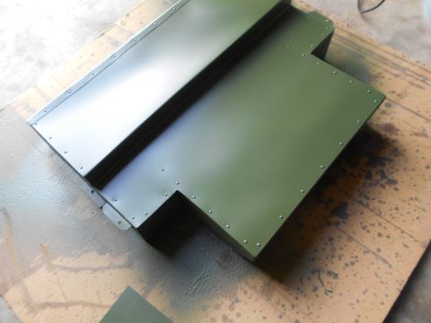1992 Ford Bronco - A green metal component, likely a vehicle part, is shown with numerous rivets along its edges.