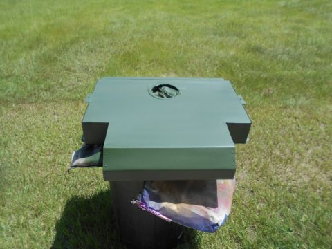 1992 Ford Bronco - A green painted metal component rests on a trash can in a grassy area.