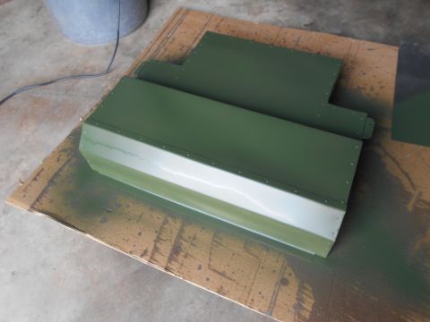 1992 Ford Bronco - Metal panels are being painted green, laid out on cardboard with overspray visible.