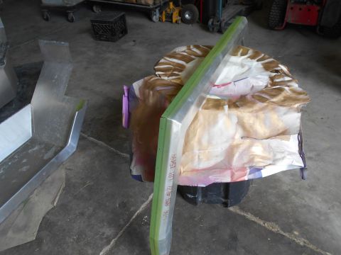 1992 Ford Bronco - A metal part with green trim and visible text is shown in a workshop setting.