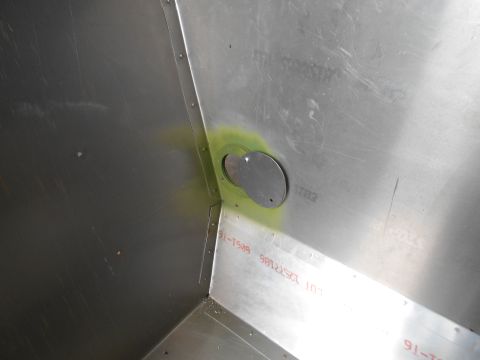1992 Ford Bronco - A close-up view of an interior metal panel shows a circular cutout with green residue and stamped text indicating a date range.