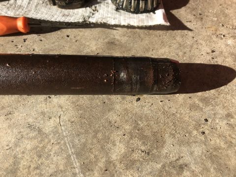 1978 Ford Bronco - Close-up of a greasy drive shaft and a bearing, likely removed for maintenance.