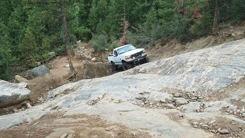 1995 Ford Bronco - White 1995 Ford Bronco navigating a challenging off-road course.