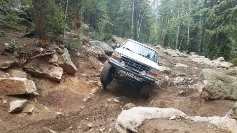 1995 Ford Bronco - An off-road SUV tackles a challenging, boulder-strewn mountain trail.