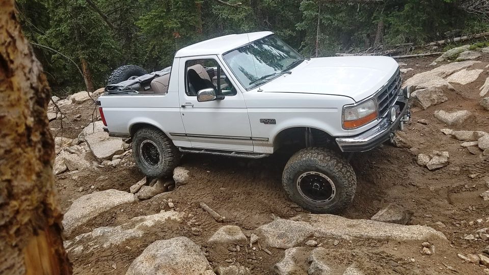 White 1995 Ford Bronco navigating a rocky trail