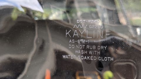 1995 Ford Bronco - A close-up view shows embossed text on a clear plastic part, including the brand name KAYLINE and cleaning instructions.