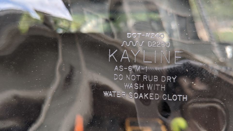 Embossed text on clear plastic part: KAYLINE, DOT-#240, AS-6 M-1, DO NOT RUB DRY, WASH WITH WATER SOAKED CLOTH